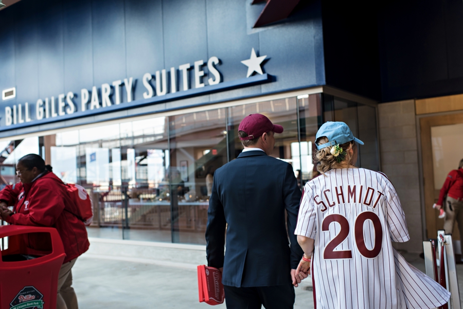 A couple walk into their wedding reception at a Phillies game.